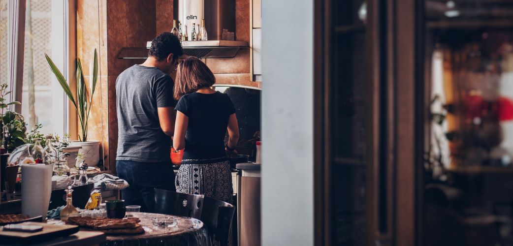 Husband and Wife Cooking Together over Gas Range