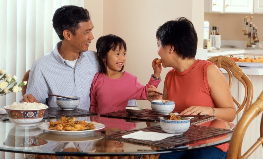 Parents Enjoying Lunchtime Meal with Daughter in Clean Kitchen